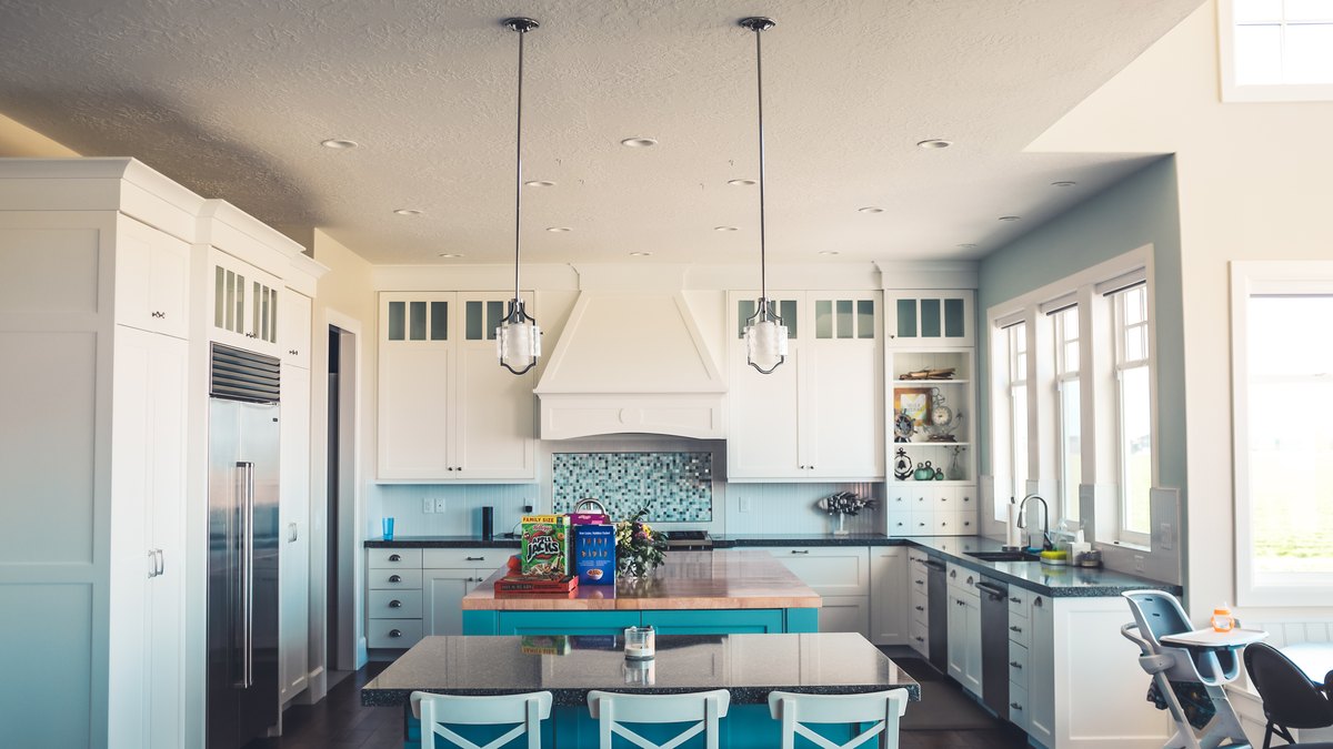 Blue and white kitchen island with bright storage and prep space