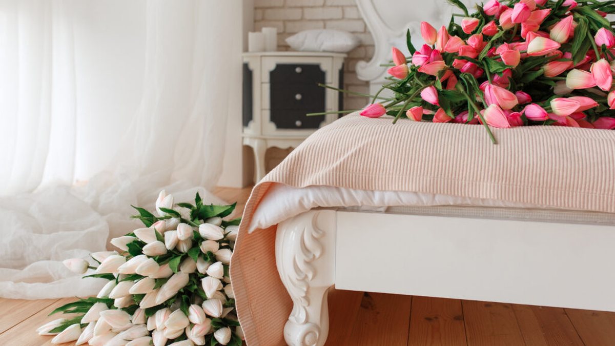 White cottage bedroom furniture with soft bedding and tulips