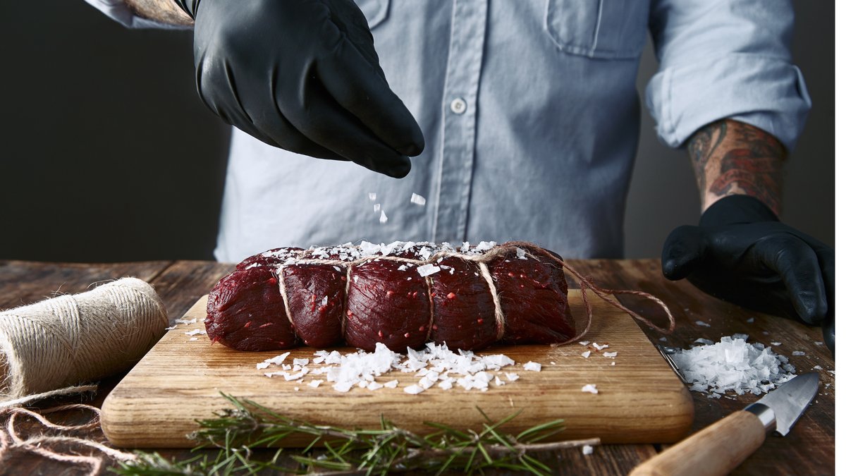 Seasoned venison hind quarter ready for roasting at home